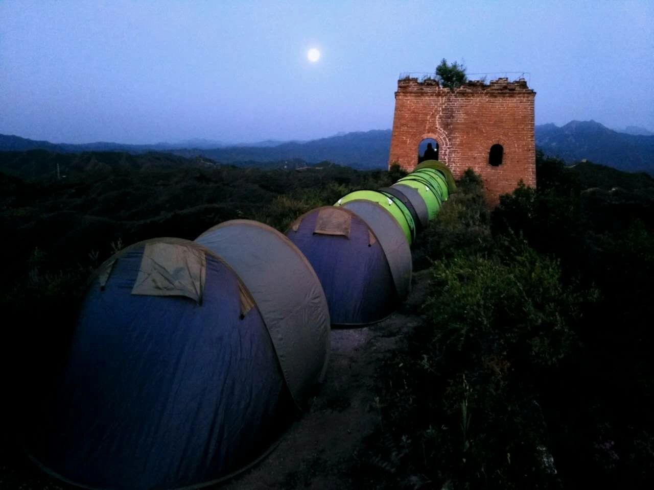 Great Wall Adventure Club camping tents beside a historic watchtower